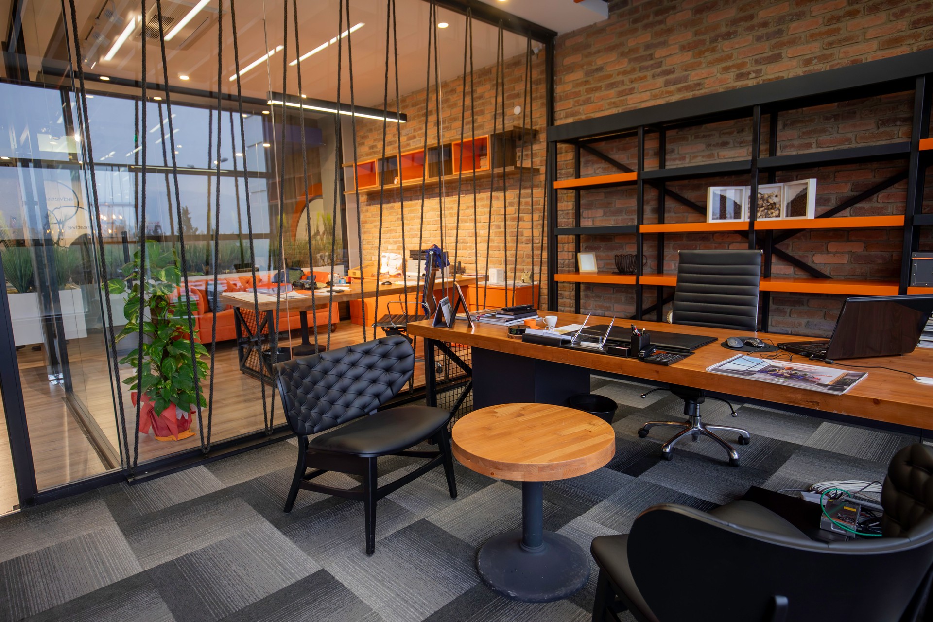 Empty Contemporary Industrial Office Interior with Brick Walls, Wooden Desk, and Minimalist Shelving in a Modern Business Workspace